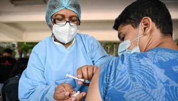 A young man receives the first dose of the Pfizer/BioNTech